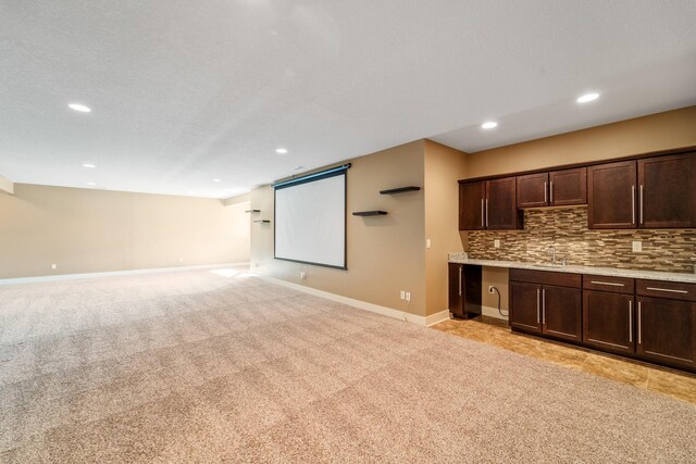 916 NE Silkwood St, Grimes, IA 50111 - kitchen with dark brown cabinets, baseboards, recessed lighting, backsplash, and light carpet