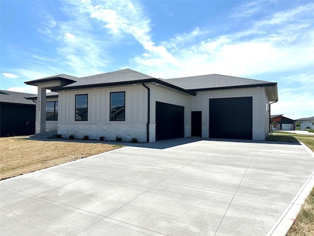 16332 Northpark Dr, Urbandale, IA 50323 - view of front facade with an attached garage, concrete driveway, a shingled roof, board and batten siding, and a front lawn