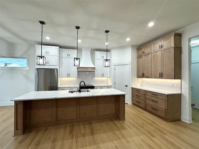 16332 Northpark Dr, Urbandale, IA 50323 - kitchen featuring custom range hood, freestanding refrigerator, a sink, light wood finished floors, and recessed lighting