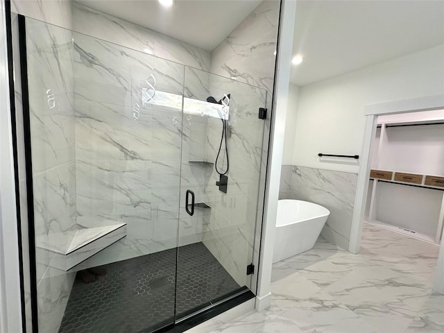 16332 Northpark Dr, Urbandale, IA 50323 - bathroom with marble finish floors, a soaking tub, a marble finish shower, tile walls, and wainscoting