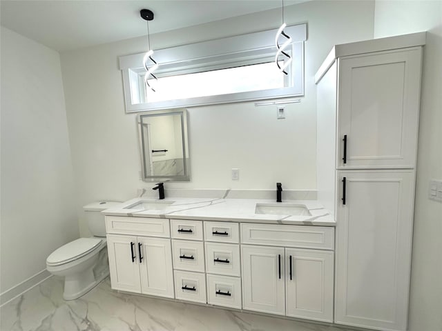 16332 Northpark Dr, Urbandale, IA 50323 - bathroom with marble finish flooring, double vanity, toilet, and baseboards