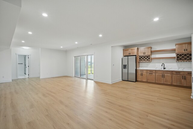 16332 Northpark Dr, Urbandale, IA 50323 - unfurnished living room featuring wet bar, light wood-style flooring, recessed lighting, and baseboards