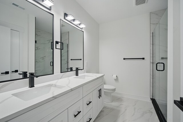 16332 Northpark Dr, Urbandale, IA 50323 - bathroom featuring marble look tile flooring, double vanity, toilet, a marble finish shower, and baseboards