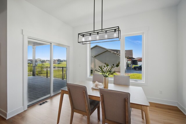 16332 Northpark Dr, Urbandale, IA 50323 - dining space featuring baseboards, light wood-type flooring, and a chandelier