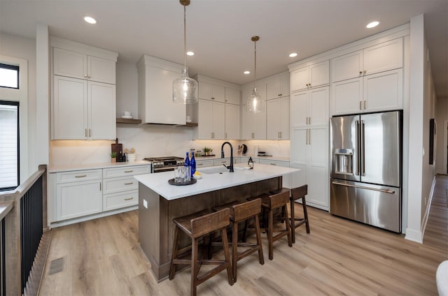 6204 Aspen Dr, West Des Moines, IA 50266 - kitchen with appliances with stainless steel finishes, a sink, light countertops, light wood-type flooring, and recessed lighting