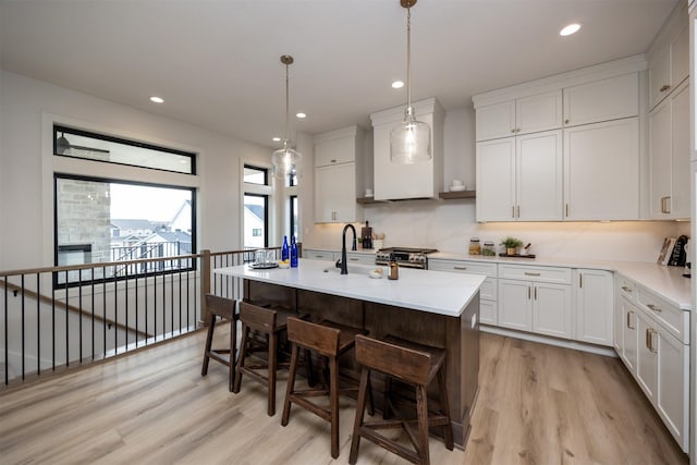6204 Aspen Dr, West Des Moines, IA 50266 - kitchen with light wood-style flooring, a sink, light countertops, a breakfast bar, and recessed lighting