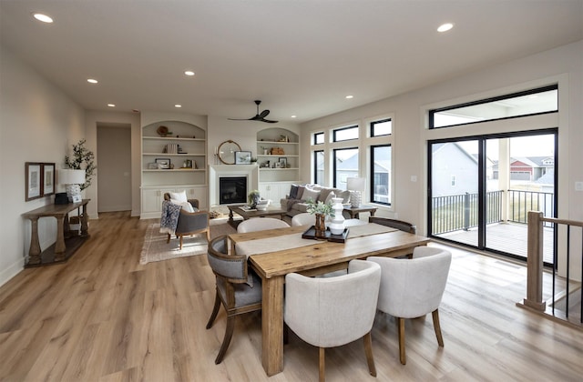 6204 Aspen Dr, West Des Moines, IA 50266 - dining space featuring recessed lighting, light wood-style floors, built in features, a glass covered fireplace, and ceiling fan