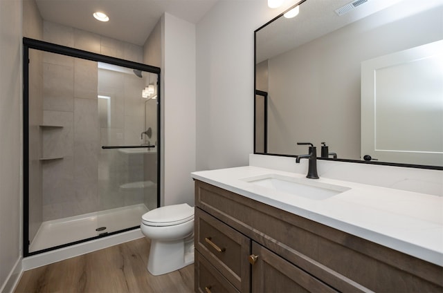 6204 Aspen Dr, West Des Moines, IA 50266 - bathroom with vanity, wood finished floors, a shower stall, toilet, and recessed lighting