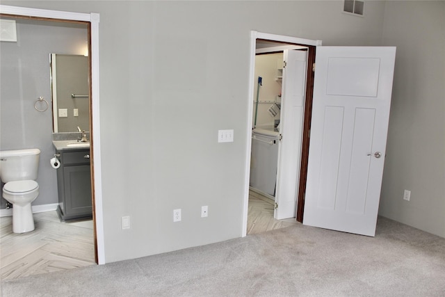 730 Kitterman Cir, Norwalk, IA 50211 - unfurnished bedroom with a sink, a spacious closet, ensuite bathroom, and light colored carpet
