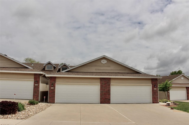 730 Kitterman Cir, Norwalk, IA 50211 - view of front of property featuring brick siding, driveway, a shingled roof, and a garage