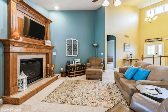 703 NE 46th Ct, Ankeny, IA 50021 - carpeted living area featuring arched walkways, a high ceiling, a fireplace, healthy amount of natural light, and a ceiling fan