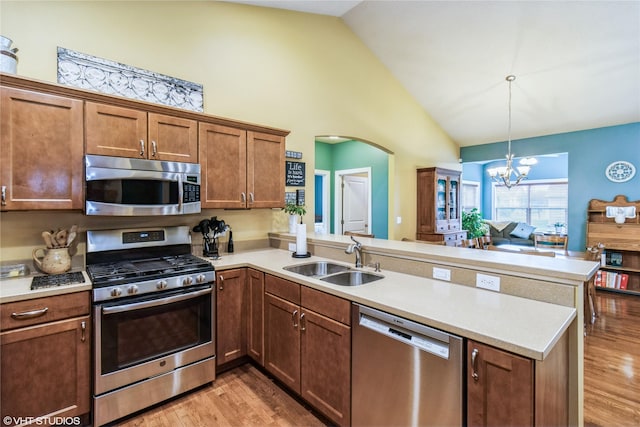 703 NE 46th Ct, Ankeny, IA 50021 - kitchen with appliances with stainless steel finishes, a peninsula, a sink, high vaulted ceiling, and a chandelier