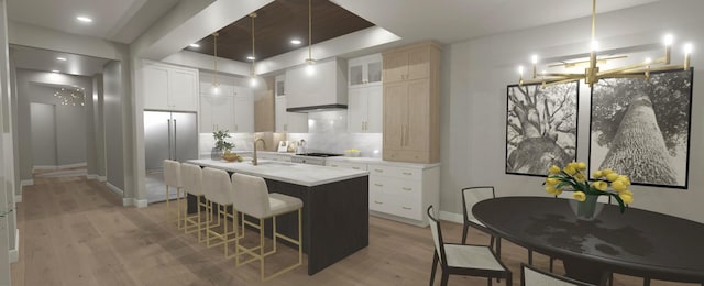 200 S Shore Dr Unit 101, Clear Lake, IA 50428 - kitchen with a sink, light wood-style floors, a kitchen bar, tasteful backsplash, and light countertops