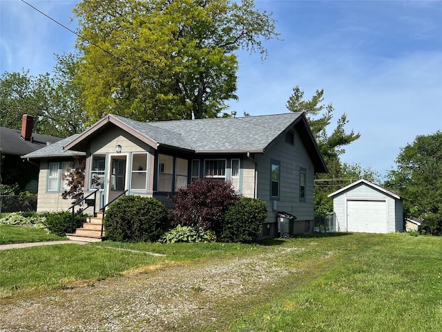 311 W 8th St S, Newton, IA 50208 - bungalow-style home featuring roof with shingles, an outbuilding, a front yard, and a detached garage