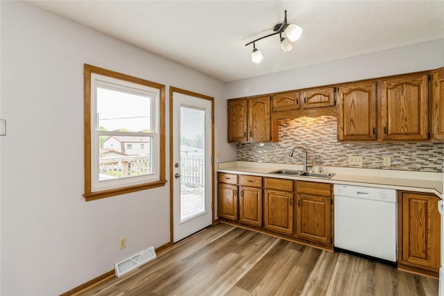 602 SE 7th St, Ankeny, IA 50021 - kitchen featuring dishwasher, a sink, brown cabinets, and light wood-style flooring