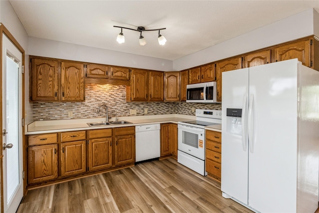 602 SE 7th St, Ankeny, IA 50021 - kitchen featuring white appliances, a sink, brown cabinetry, and light wood finished floors