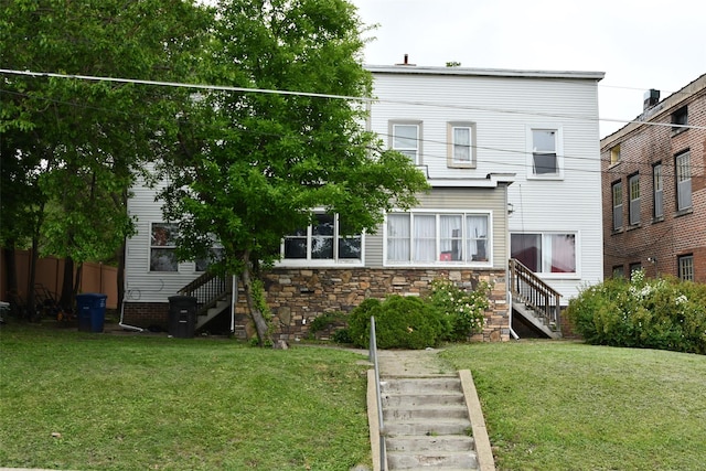 1418 8th St, Des Moines, IA 50314 - back of house with stairs, a lawn, and stone siding
