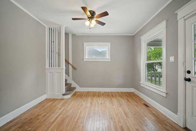 3114 School St, Des Moines, IA 50311 - spare room featuring ornamental molding, wood-type flooring, baseboards, stairway, and a ceiling fan