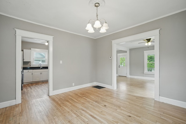 3114 School St, Des Moines, IA 50311 - spare room with a chandelier, light wood finished floors, healthy amount of natural light, crown molding, and a ceiling fan