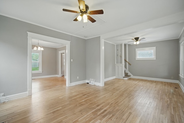 3114 School St, Des Moines, IA 50311 - empty room featuring a ceiling fan, light wood finished floors, crown molding, stairs, and baseboards