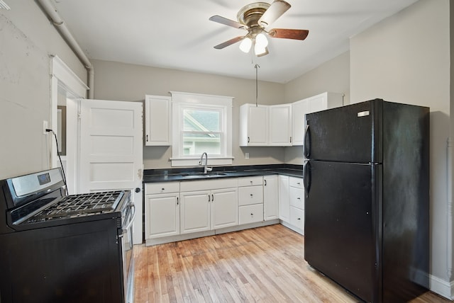3114 School St, Des Moines, IA 50311 - kitchen with freestanding refrigerator, stainless steel range with gas cooktop, a sink, a ceiling fan, and dark countertops