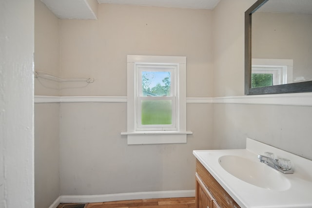 3114 School St, Des Moines, IA 50311 - bathroom featuring vanity, baseboards, and wood finished floors