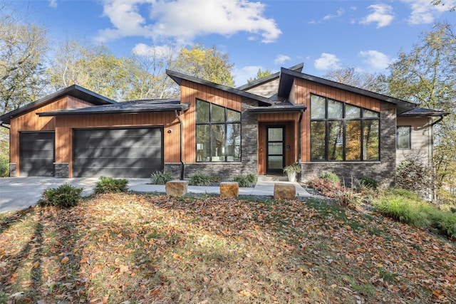 5705 SW Landview Dr, West Des Moines, IA 50265 - contemporary home featuring stone siding, an attached garage, and driveway