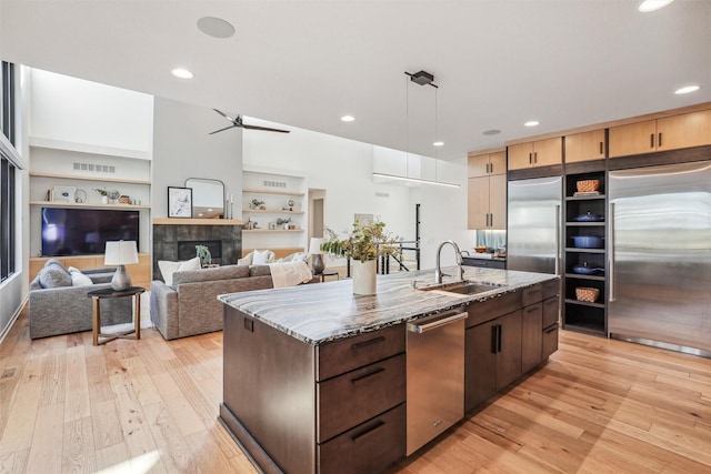 5705 SW Landview Dr, West Des Moines, IA 50265 - kitchen with stainless steel appliances, a sink, light wood-style floors, an island with sink, and recessed lighting
