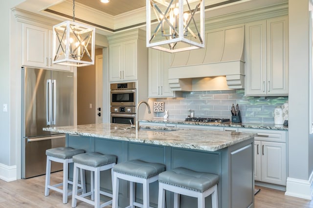 2315 14th St SW, Altoona, IA 50009 - kitchen with stainless steel appliances, a chandelier, a raised ceiling, a sink, and decorative backsplash
