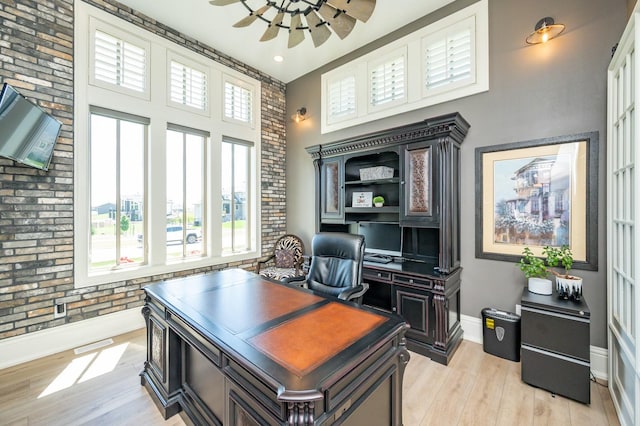 2315 14th St SW, Altoona, IA 50009 - office with baseboards, light wood-style flooring, brick wall, and a towering ceiling
