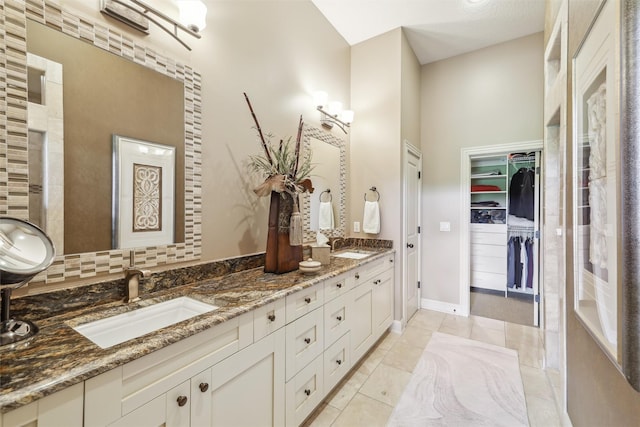1176 Glen Oaks Dr, West Des Moines, IA 50266 - bathroom featuring double vanity, a spacious closet, baseboards, and tile patterned floors