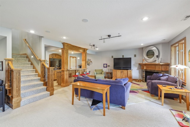 1176 Glen Oaks Dr, West Des Moines, IA 50266 - living room featuring stairs, light carpet, recessed lighting, rail lighting, and a fireplace