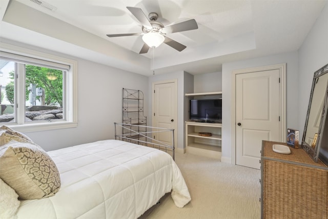 1176 Glen Oaks Dr, West Des Moines, IA 50266 - bedroom featuring a tray ceiling, light carpet, and ceiling fan