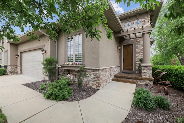 1176 Glen Oaks Dr, West Des Moines, IA 50266 - view of exterior entry with stone siding, stucco siding, concrete driveway, and a garage