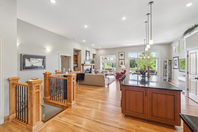 1176 Glen Oaks Dr, West Des Moines, IA 50266 - kitchen with dark countertops, light wood finished floors, recessed lighting, and brown cabinetry
