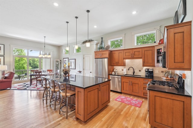 1176 Glen Oaks Dr, West Des Moines, IA 50266 - kitchen featuring appliances with stainless steel finishes, dark countertops, light wood-style flooring, a sink, and recessed lighting