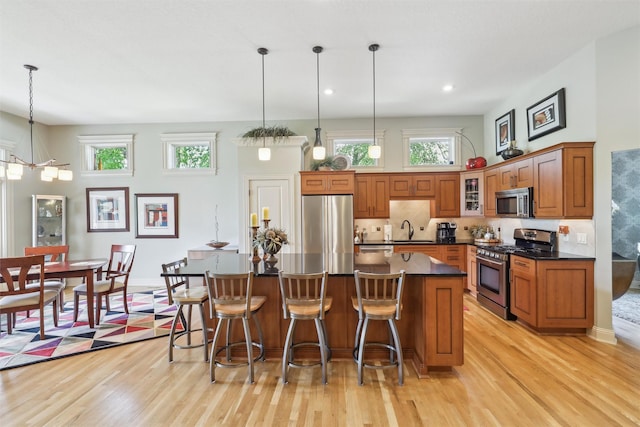 1176 Glen Oaks Dr, West Des Moines, IA 50266 - kitchen featuring appliances with stainless steel finishes, a sink, brown cabinetry, light wood-style floors, and recessed lighting