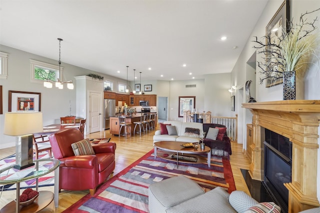 1176 Glen Oaks Dr, West Des Moines, IA 50266 - living area with light wood finished floors, a premium fireplace, and recessed lighting