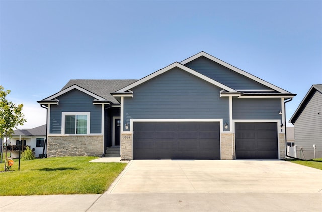 3309 NW Reinhart Dr, Ankeny, IA 50023 - view of front of house featuring concrete driveway, an attached garage, a front yard, and stone siding