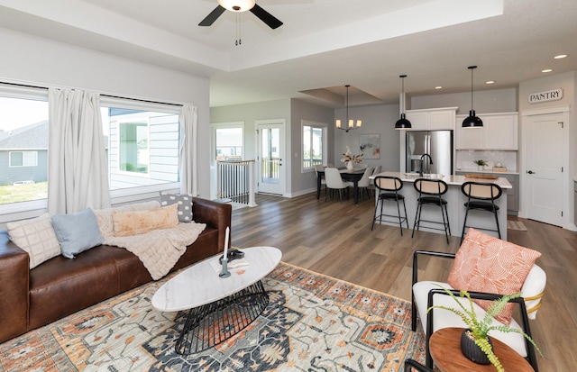3309 NW Reinhart Dr, Ankeny, IA 50023 - living room with ceiling fan, wood finished floors, healthy amount of natural light, recessed lighting, and a raised ceiling