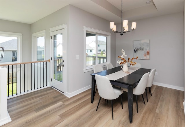3309 NW Reinhart Dr, Ankeny, IA 50023 - dining area with a chandelier, light wood-style floors, and baseboards