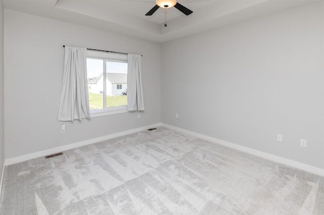 3309 NW Reinhart Dr, Ankeny, IA 50023 - carpeted empty room featuring a ceiling fan, a raised ceiling, and baseboards