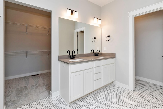 3309 NW Reinhart Dr, Ankeny, IA 50023 - bathroom with double vanity, baseboards, tile patterned flooring, and a spacious closet