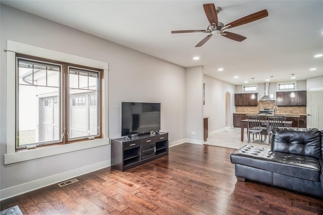 2658 SW 20th Cir, Ankeny, IA 50023 - living room featuring arched walkways, a ceiling fan, baseboards, wood finished floors, and recessed lighting