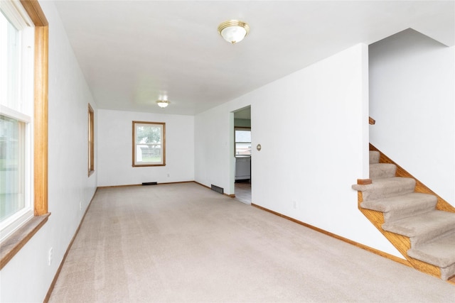 221 W Division St, Colfax, IA 50054 - spare room with carpet flooring, stairs, and baseboards