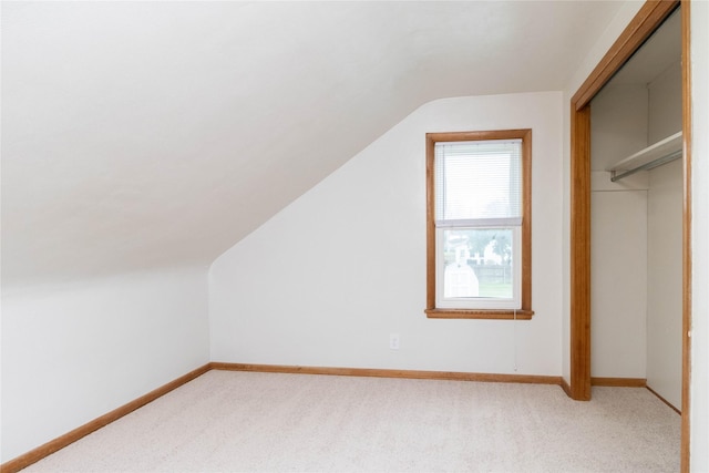 221 W Division St, Colfax, IA 50054 - additional living space with vaulted ceiling, light carpet, and baseboards