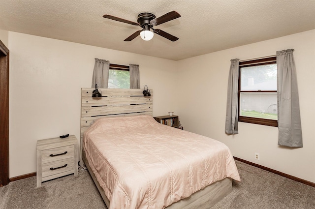 1406 110th Pl, Knoxville, IA 50138 - bedroom with carpet floors, baseboards, a textured ceiling, and ceiling fan