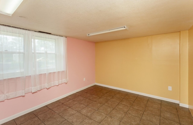 1406 110th Pl, Knoxville, IA 50138 - empty room with a textured ceiling, tile patterned flooring, and baseboards