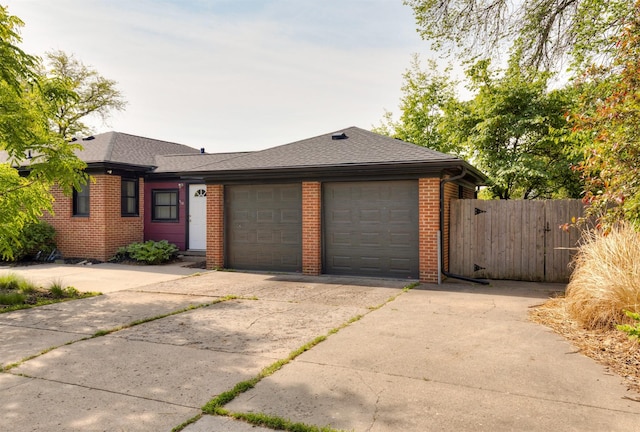 936 15th St, West Des Moines, IA 50265 - view of front of house with brick siding, a garage, concrete driveway, and a shingled roof