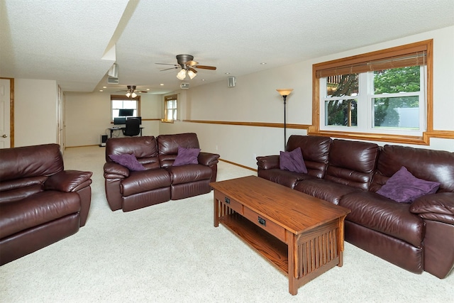 5525 SE 29th Ct, Des Moines, IA 50320 - carpeted living room featuring a ceiling fan, a textured ceiling, healthy amount of natural light, and a desk